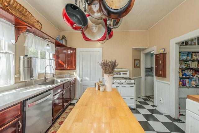 kitchen with range with two ovens, dishwasher, sink, and butcher block countertops