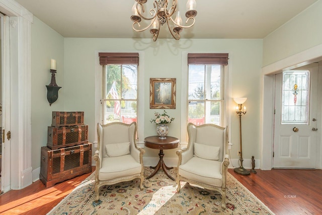 living area featuring an inviting chandelier and hardwood / wood-style floors