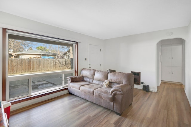 living room with heating unit and hardwood / wood-style floors