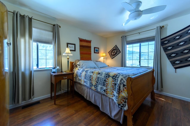 bedroom with multiple windows and dark hardwood / wood-style floors