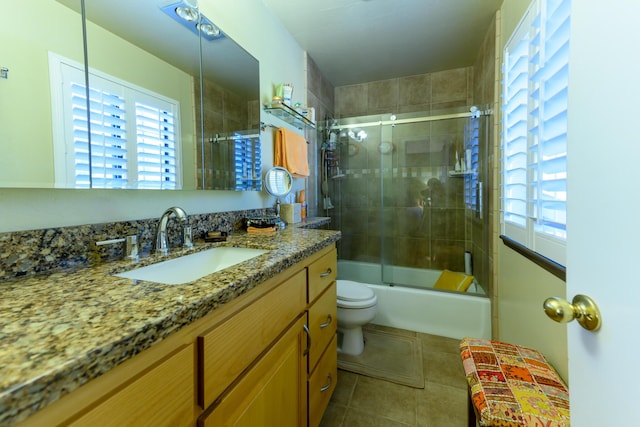 full bathroom featuring tile patterned flooring, bath / shower combo with glass door, toilet, and a healthy amount of sunlight