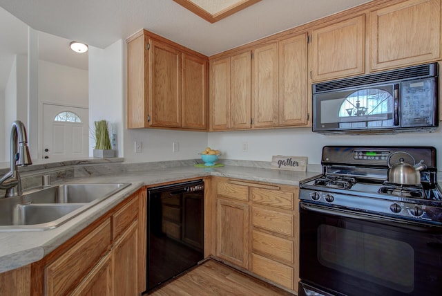 kitchen featuring sink, kitchen peninsula, light hardwood / wood-style floors, and black appliances