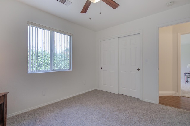 unfurnished bedroom with light colored carpet, ceiling fan, and a closet