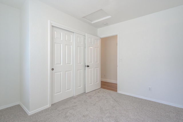 unfurnished bedroom with light colored carpet and a closet