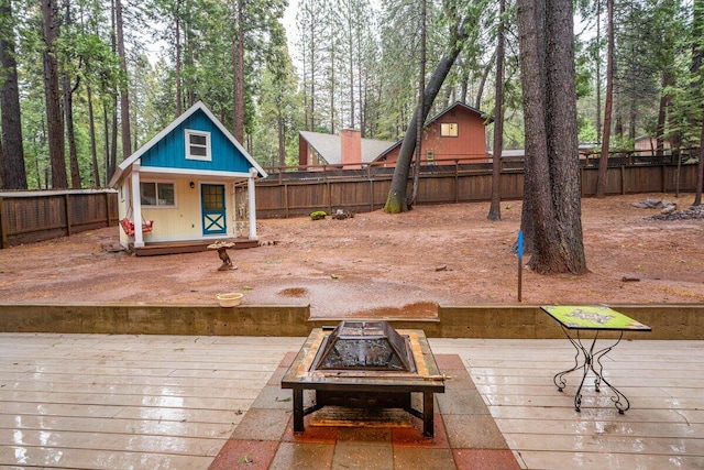 wooden deck featuring a fire pit and an outdoor structure