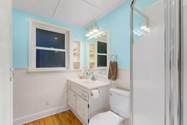 bathroom featuring vanity, hardwood / wood-style floors, ornamental molding, and toilet