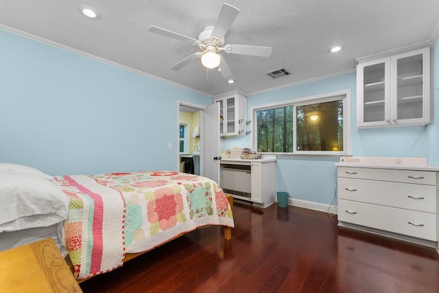 bedroom with a textured ceiling, dark wood-type flooring, ornamental molding, and ceiling fan