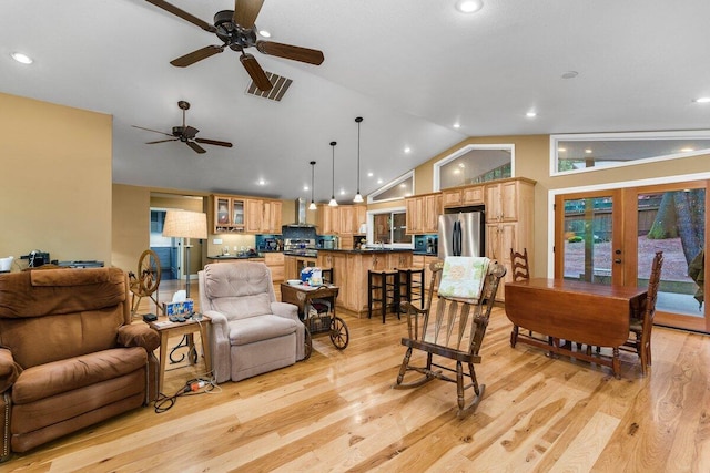 living room featuring vaulted ceiling, ceiling fan, light wood-type flooring, and french doors