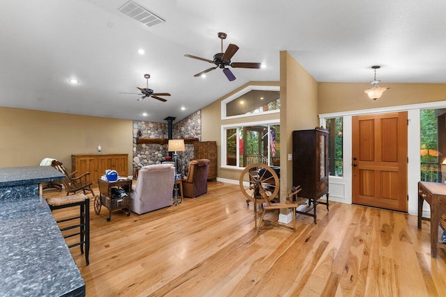 living room featuring ceiling fan, lofted ceiling, and light hardwood / wood-style floors