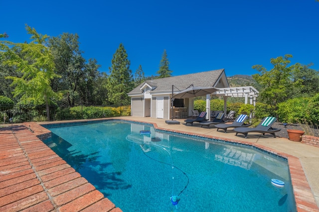 view of swimming pool featuring an outbuilding, a pergola, and a patio