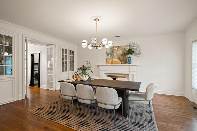 dining space with an inviting chandelier, ornamental molding, and dark hardwood / wood-style floors