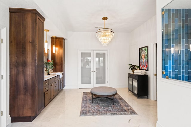 foyer entrance featuring a notable chandelier and french doors