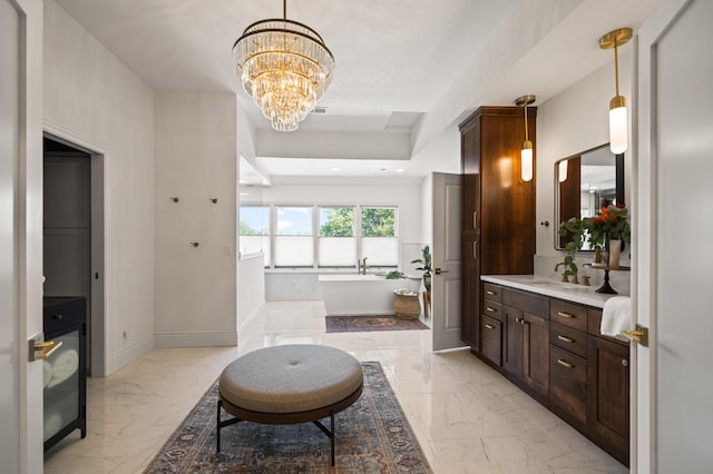 bathroom with vanity, a notable chandelier, and a tub