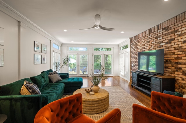 living room featuring ornamental molding, wood-type flooring, and ceiling fan