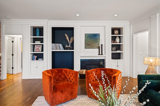 sitting room featuring hardwood / wood-style flooring, ornamental molding, and built in features