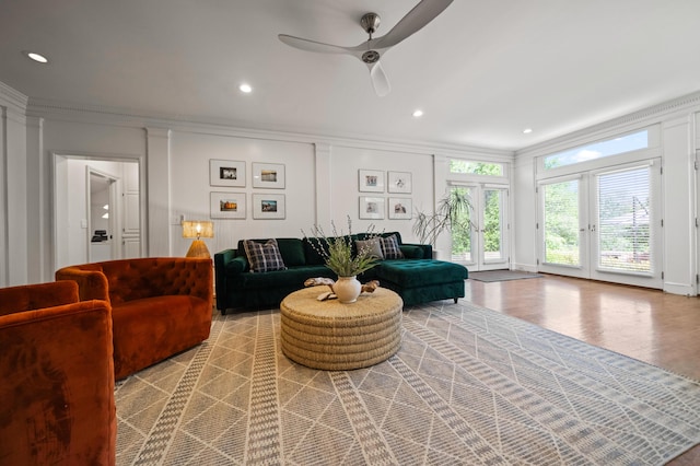 living room featuring crown molding, light hardwood / wood-style floors, and ceiling fan