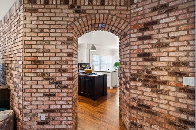 kitchen featuring pendant lighting, ornamental molding, light wood-type flooring, and white cabinets