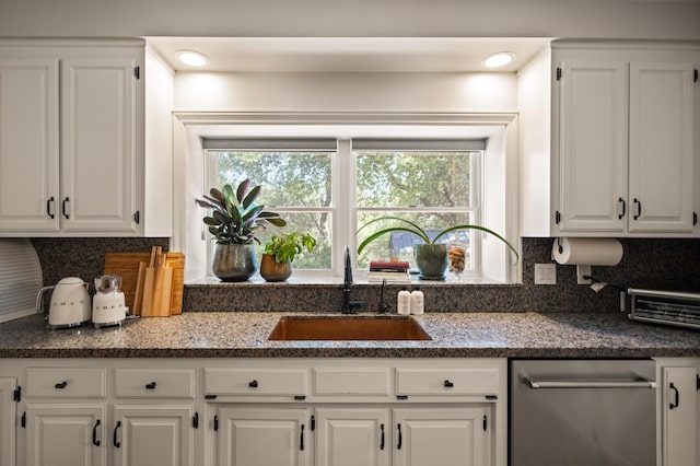 kitchen featuring backsplash, dishwasher, sink, and white cabinets