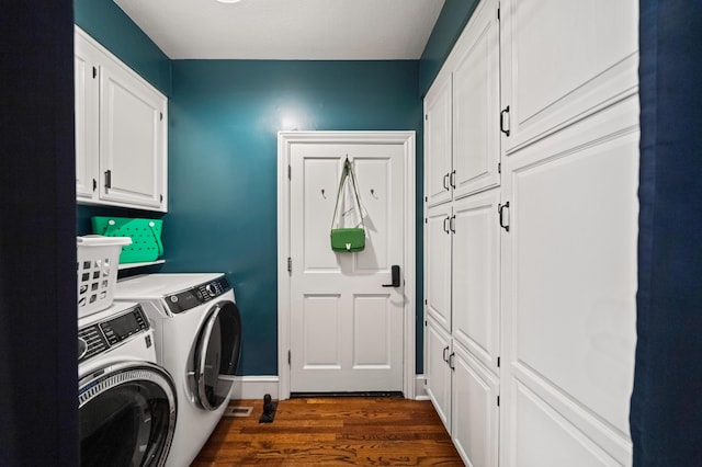 washroom with dark hardwood / wood-style floors, washer and clothes dryer, and cabinets