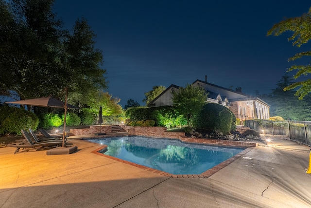 pool at twilight featuring a patio