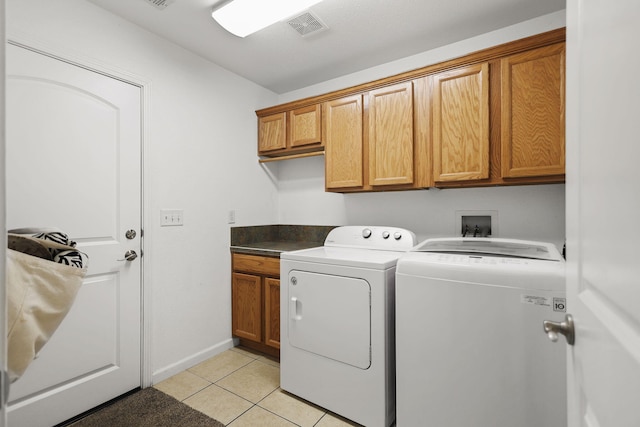 laundry room with light tile patterned floors, baseboards, visible vents, washing machine and clothes dryer, and cabinet space