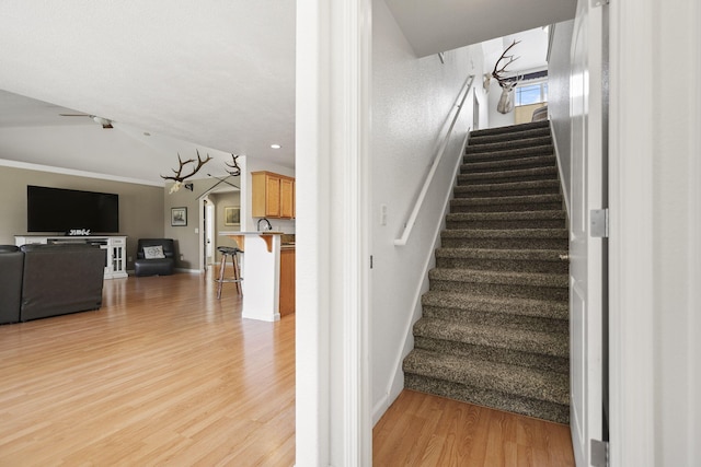 staircase featuring baseboards and wood finished floors