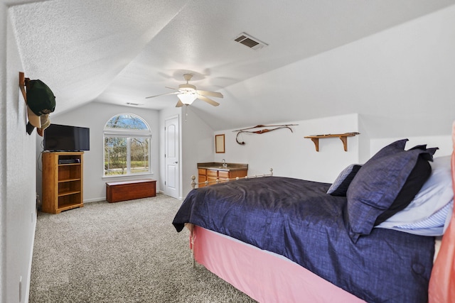carpeted bedroom featuring visible vents, a ceiling fan, a textured ceiling, baseboards, and lofted ceiling