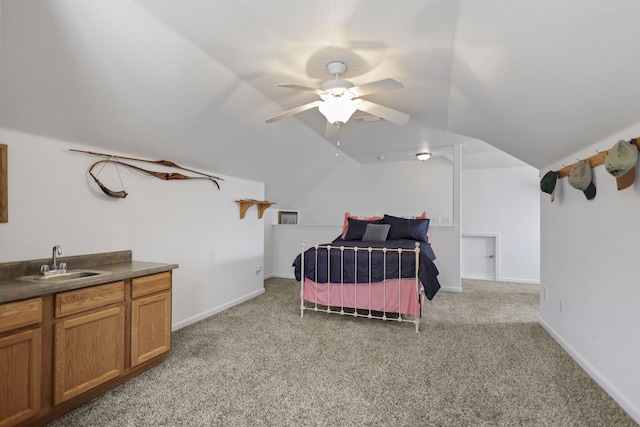 bedroom featuring a ceiling fan, carpet, baseboards, lofted ceiling, and a sink