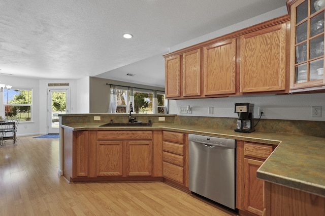 kitchen with light wood-type flooring, brown cabinets, a sink, a peninsula, and dishwasher