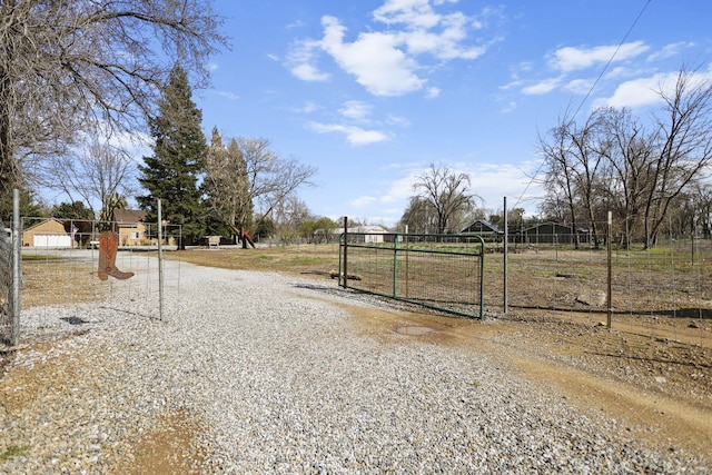 view of street with a gated entry, gravel driveway, and a gate