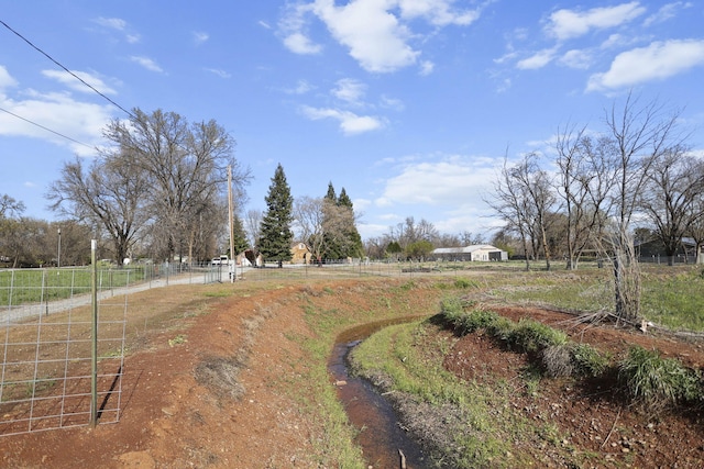 view of yard with a rural view and fence