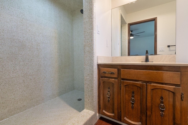 bathroom featuring tiled shower and vanity