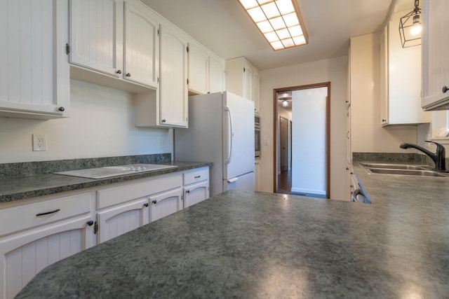 kitchen with white cabinetry, sink, and white appliances