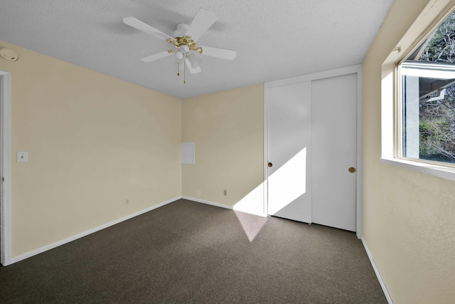 carpeted spare room featuring ceiling fan and a textured ceiling