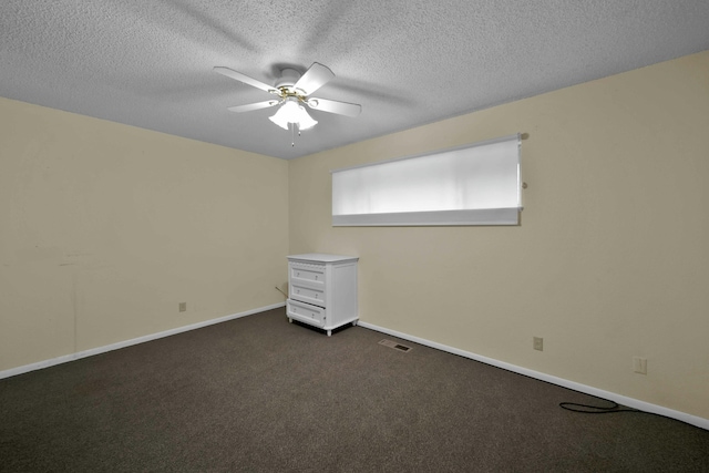 spare room with dark colored carpet, a textured ceiling, and ceiling fan