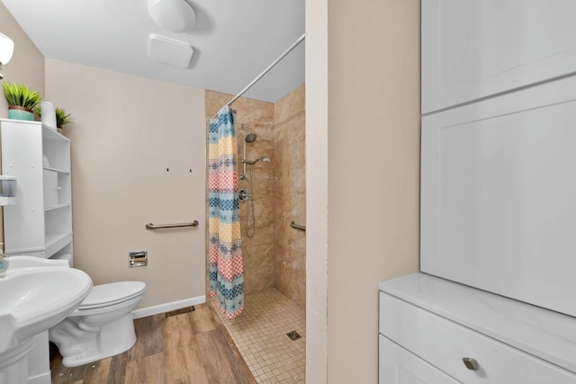 bathroom with wood-type flooring, sink, curtained shower, and toilet