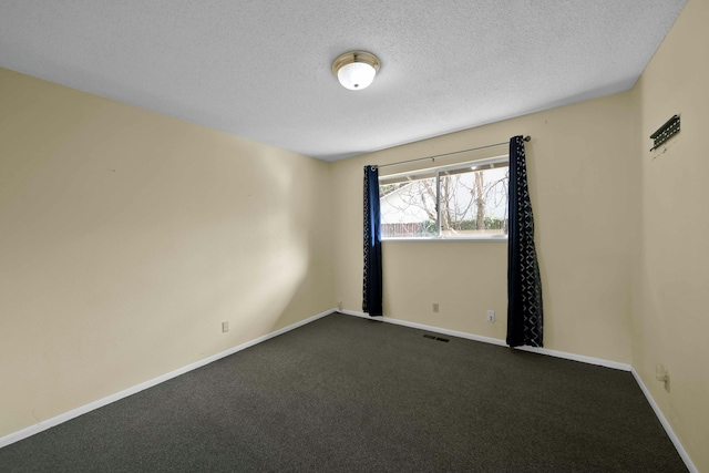 spare room with a textured ceiling and carpet