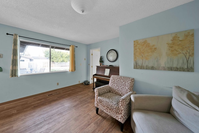 sitting room featuring hardwood / wood-style floors and a textured ceiling