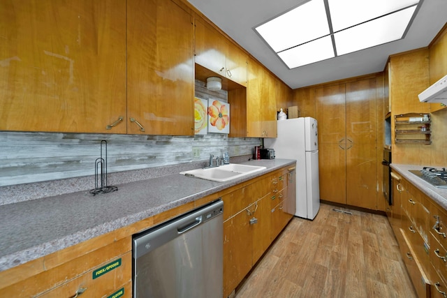 kitchen featuring sink, tasteful backsplash, light wood-type flooring, stainless steel dishwasher, and white fridge