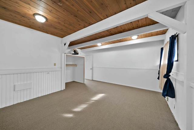 interior space with wood ceiling, beam ceiling, and dark colored carpet