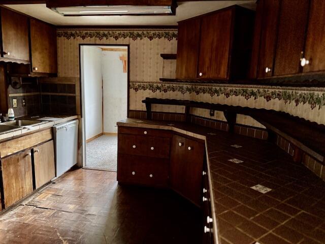 kitchen with white dishwasher, tile countertops, and backsplash