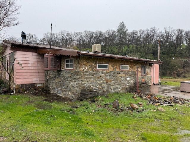 view of side of property with cooling unit and a yard