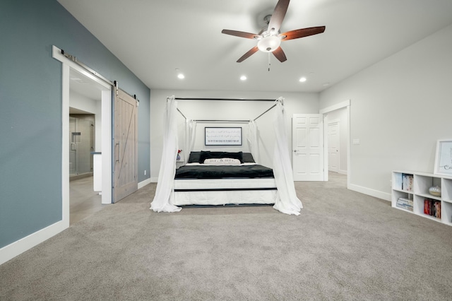 bedroom with a barn door, light carpet, and ceiling fan