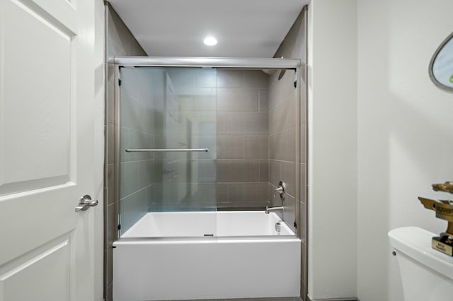 bathroom with enclosed tub / shower combo and toilet