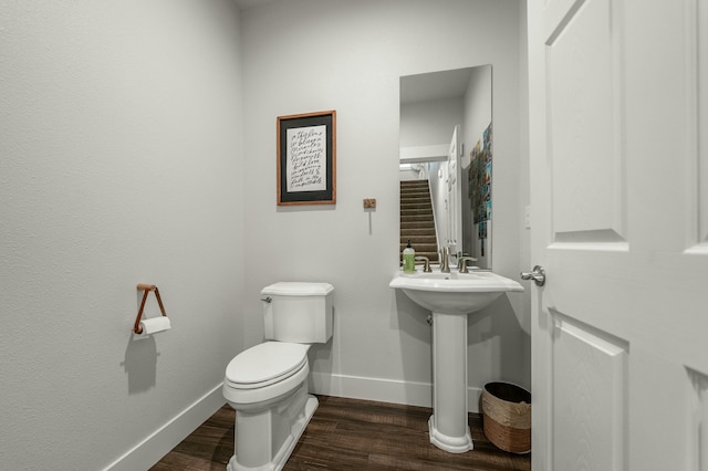 bathroom with hardwood / wood-style flooring, toilet, and sink