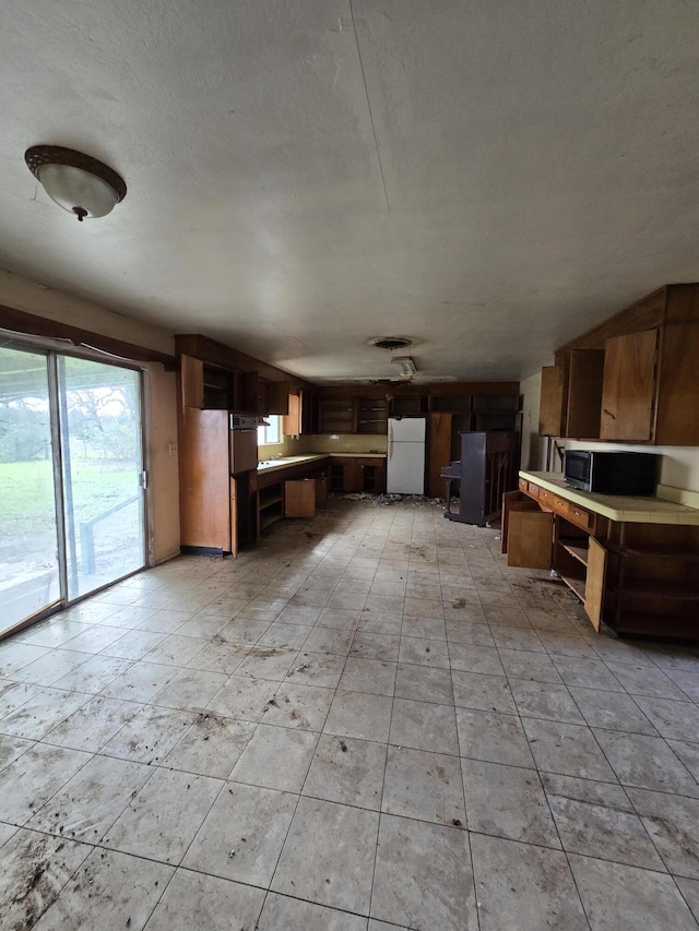 interior space featuring white refrigerator and a textured ceiling