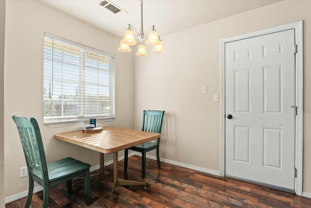 dining area featuring dark hardwood / wood-style flooring and an inviting chandelier