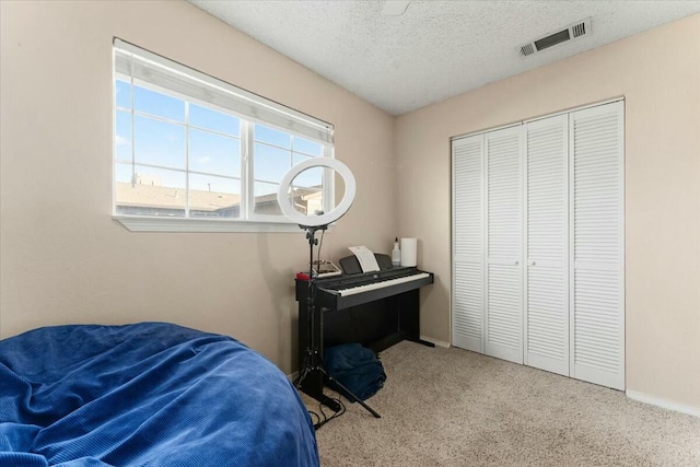 carpeted bedroom featuring a closet and a textured ceiling