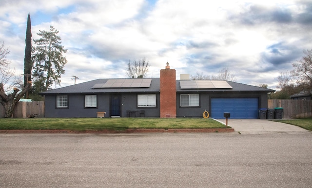 ranch-style house with a garage, a front lawn, and solar panels