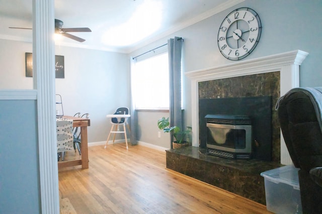 living room featuring ornamental molding, a high end fireplace, hardwood / wood-style floors, and ceiling fan